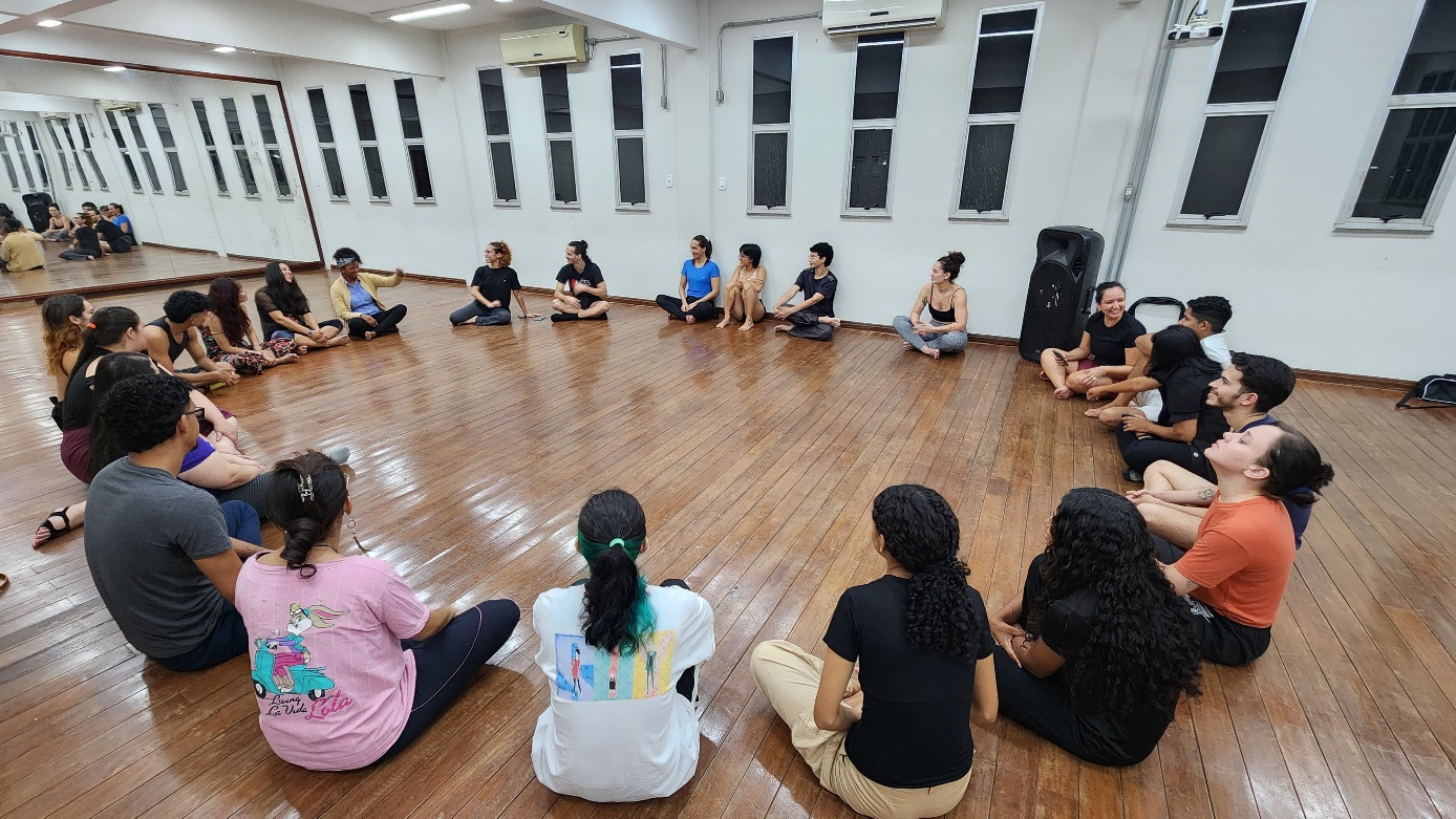 Participantes da oficina O Corpo Criativo sentados em roda no laboratório de Artes Cênicas da UFAC