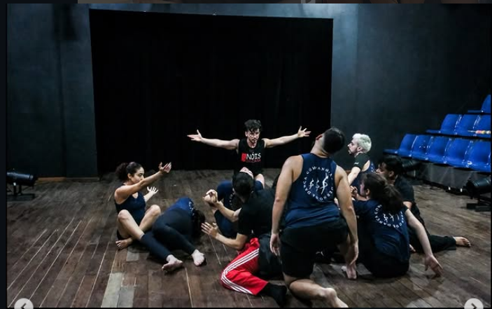 Artistas em exercício coletivo no palco durante o intercâmbio com a Companhia Moderna de Dança